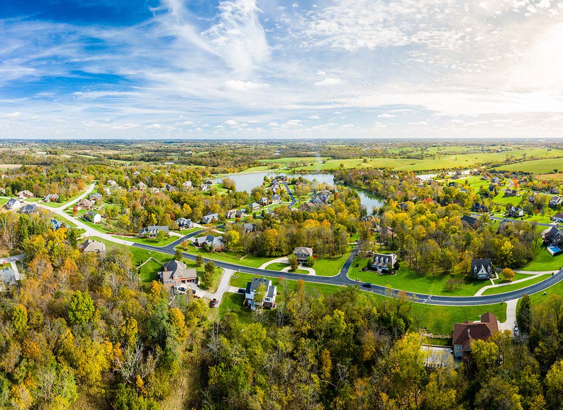 Insurance Solutions - View of Residential Neighborhood in Rural Kentucky with Homes Surrounded by Green Grass and Trees on a Sunny Day